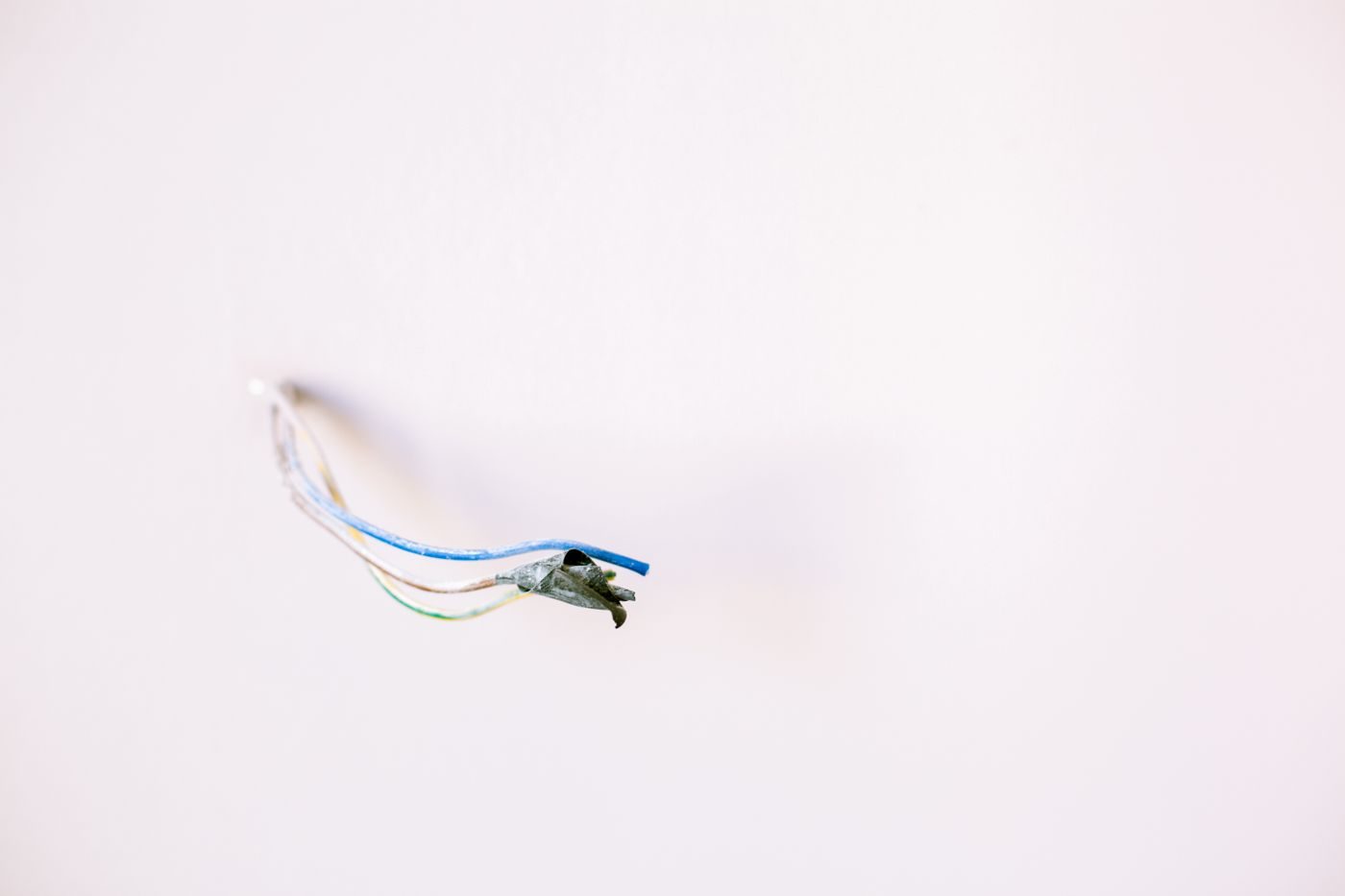 Loose cable ends left safe and isolated coming out of a white wall